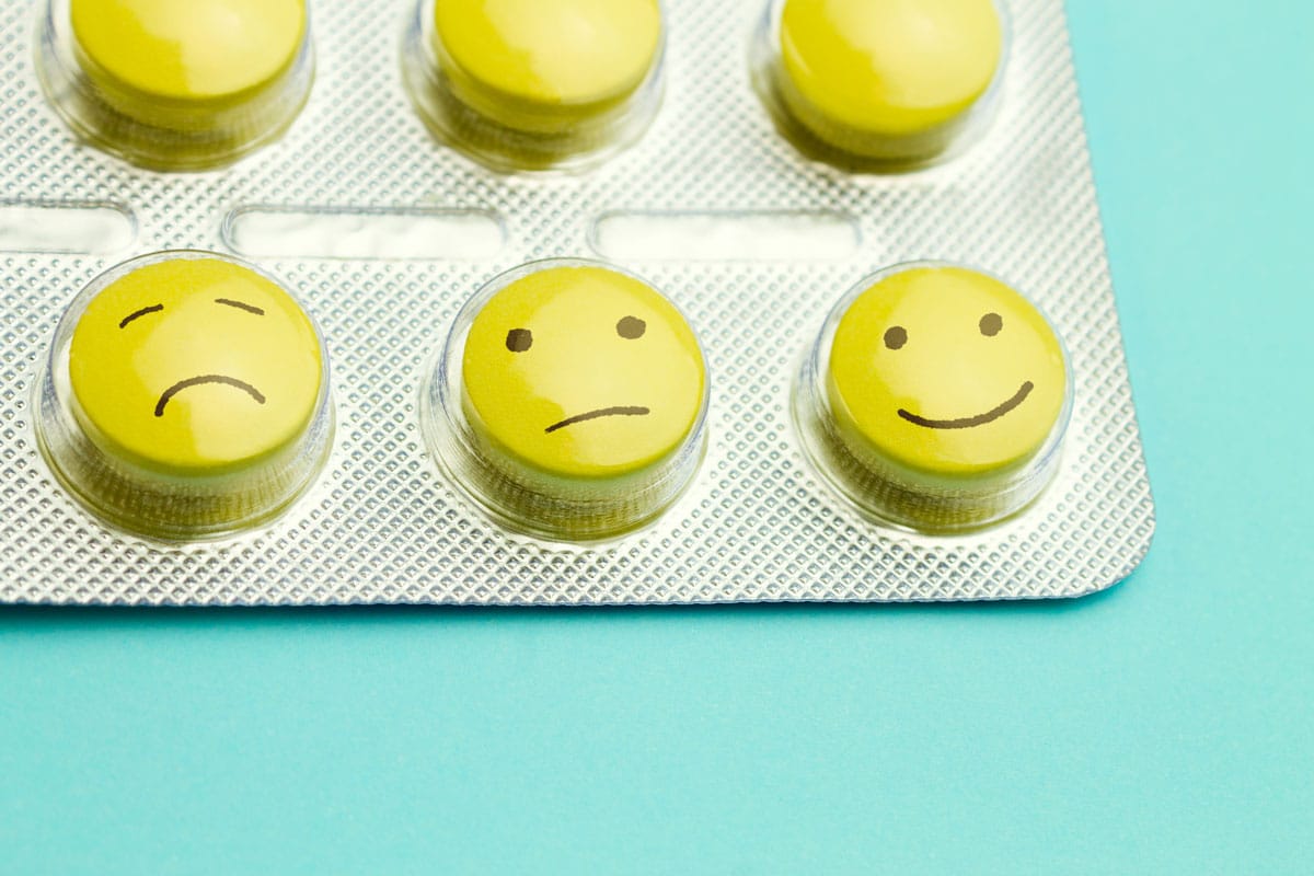 Pills in blister pack, from sad face to normal face to smiley face